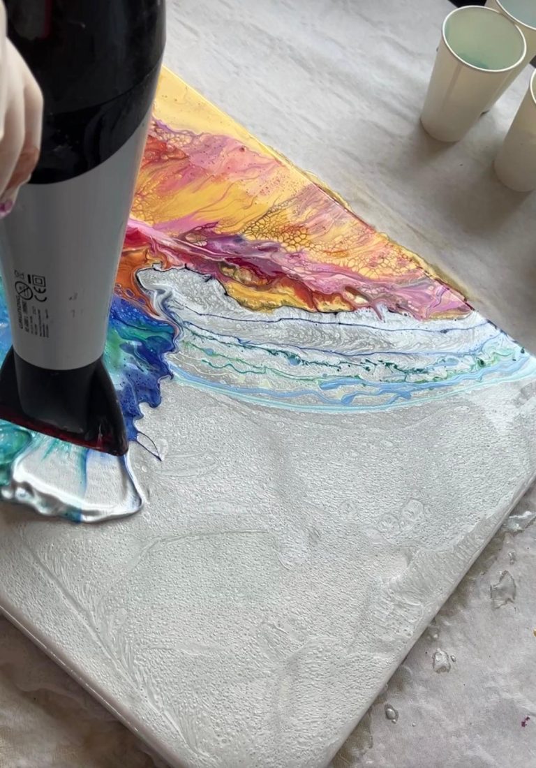 Haartrockner über bemaltem Untergrund, Farben mischen sich und verlaufen.