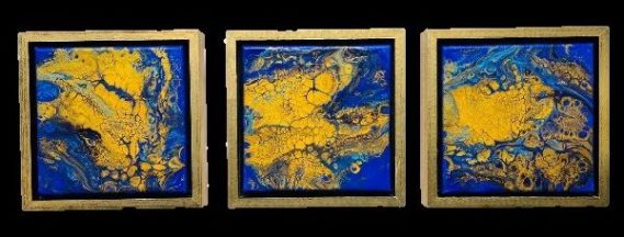 Drei goldene und blaue abstrakte Gemälde nebeneinander angeordnet.